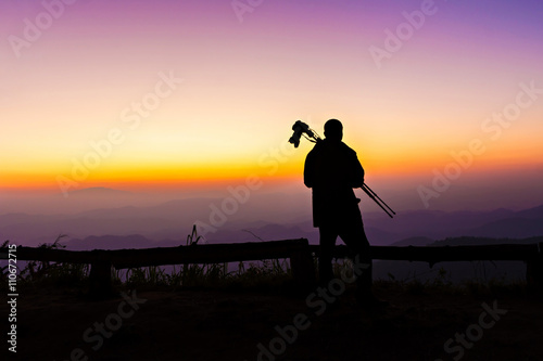 Silhouette of photographer standing at view point in twilight