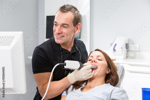 Dentist scanning patient's teeth with a CEREC scanner
