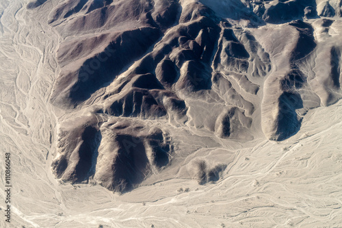 Aerial view of geoglyphs near Nazca - famous Nazca Lines, Peru. On the bottom, small Astronaut figure is present.