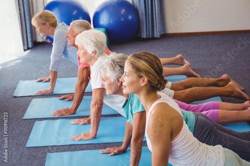 Seniors and fitness instructor stretching their legs