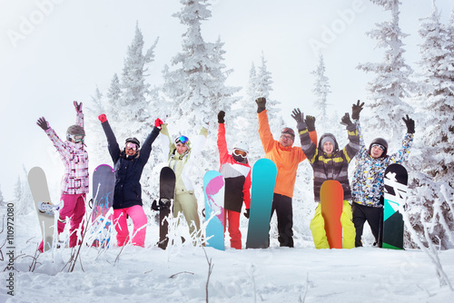 Group of friends skiers and snowboarders having fun on snowbound winter forest. Sheregesh resort, Siberia, Russia