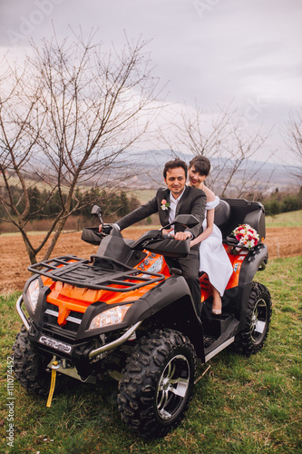 Man and woman having fun on an off road adventure. Couple riding on a quad bike in countryside on a summer day.