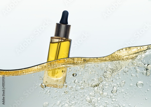 The bottle of the yellow cosmetic oil in the yellow oil emulsion wave