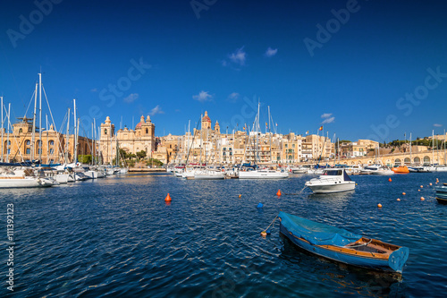 Sailboat on a background of yachts in the port of Valletta, Malta.