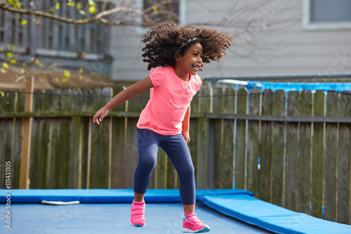 Kid toddler girl jumping on a trampoline