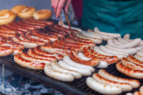 rows of bratwurst on a large grill