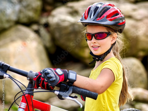 Bikes bicyclist girl. Girl with smart watch rides bicycle into mountains. Girl wearing helmet and gloves on bicycle in mountaineering . Mountaineering is good for health. 