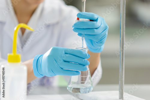 The woman who’s the scientist is demonstrate the titration technician