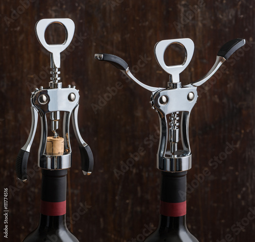 Wing Corkscrew Opening a Bottle of Wine on Wooden Background