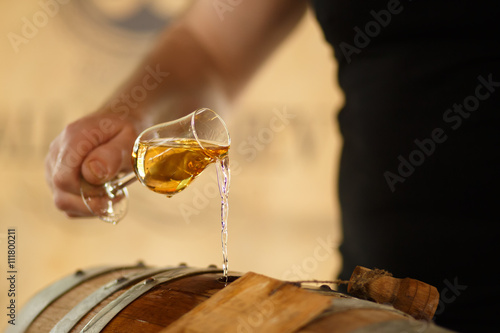 pour whiskey in barrels