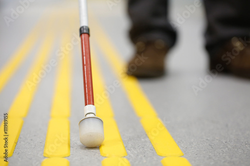 Blind pedestrian walking on tactile paving