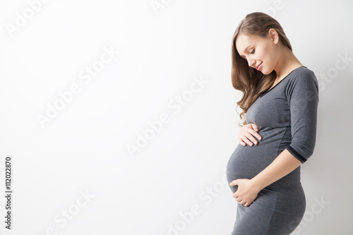 Isolated portrait of beautiful smiling woman in dress waiting for baby