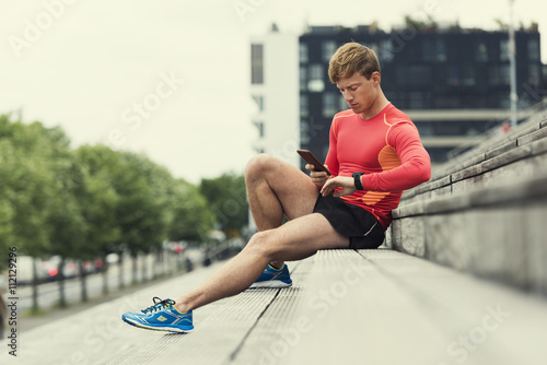 Jogger checking sport performance on his mobile phone 