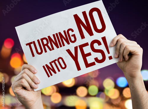 Turning No Into Yes placard with night lights on background