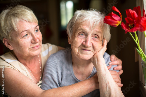 Portrait of an elderly woman of eighty years with her daughter.