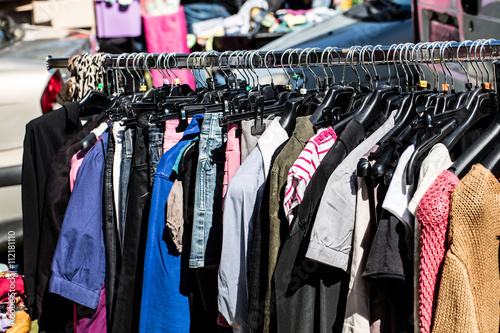 various fast fashion female clothes on rack at street fair