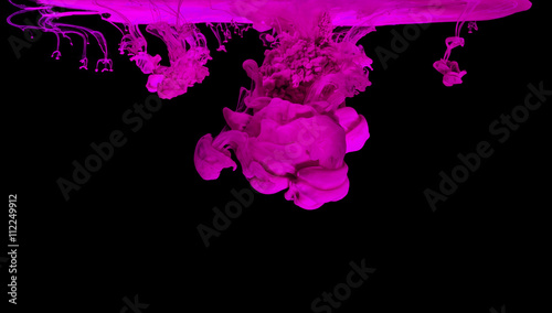 Pink ink in water creating abstract shape