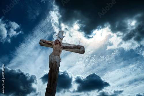 Christian cross over dark stormy sky background