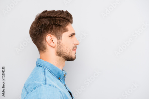 Side view of young bearded man isolated on gray background