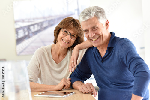 Senior couple at home using digital tablet