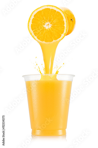 Pure orange juice pouring out from fruit in plastic cup
