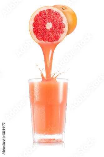 Pure grapefruit juice pouring out from fruit in glass