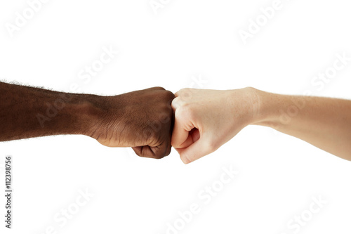 Black African American man touching knuckles with white Caucasian woman in agreement, partnership and cooperation. Two people of different cultures and races greeting each other in modern handshake