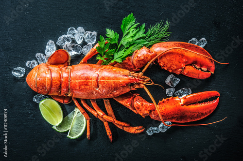 Top view of whole red lobster with ice and lime