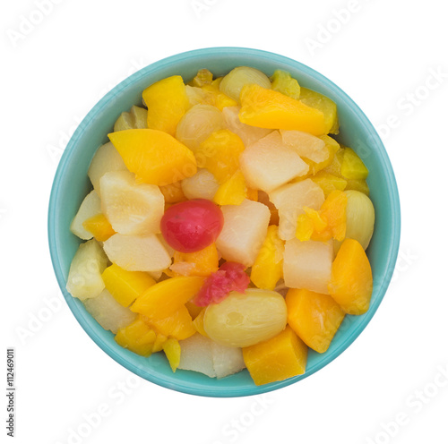 Top view of a bowl filled with fruit cocktail isolated on a white background.