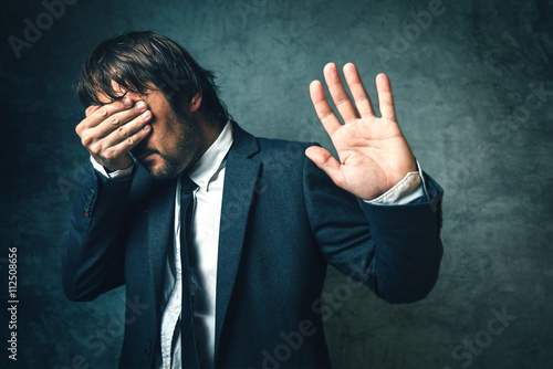 Crooked politician hiding face from photographers after politica