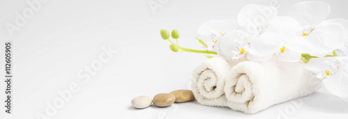 Spa orchidea z miękkimi ręcznikami i kamieniami do masażu