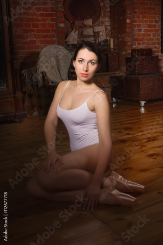 Young ballerina in a dark room