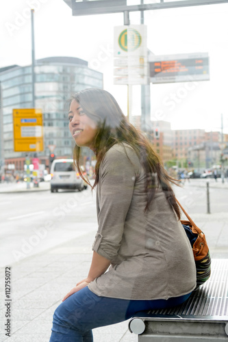 Deutschland, Berlin, junge Frau wartet an der Bushaltestelle, To