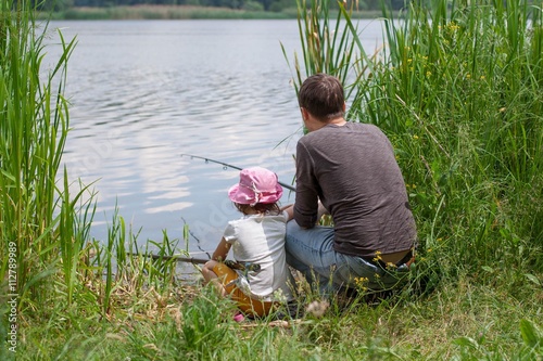 Father and daughter fishing on the lake