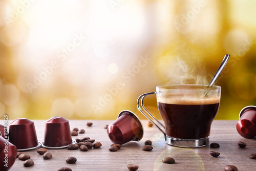 Cup of coffee with capsules and bainas and local background