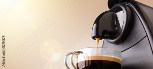 Espresso machine making coffee with beige gradient background