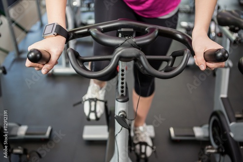 Woman working out on exercise bike at spinning class