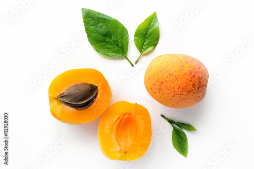 Fresh whole and sliced apricot with leaves. Isolated. White background