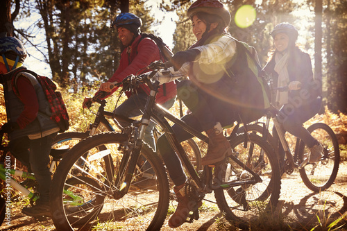 Family riding bikes on a forest path, close up