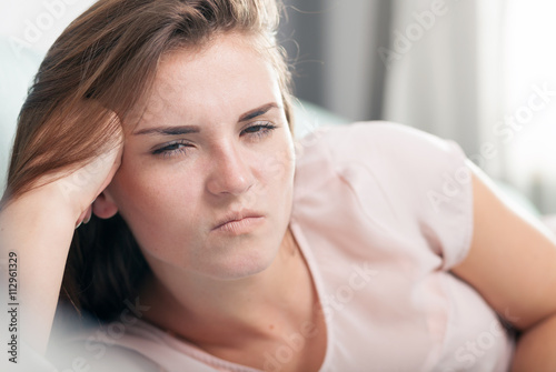 Young woman lying on couch and she is angry. Casual style indoor shoot