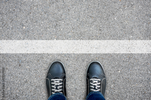 Black casual shoes standing at the white line