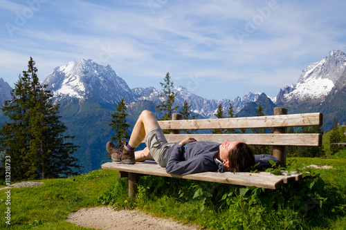 Frau entpannt auf einer Bank mit Blick auf den Watzmann