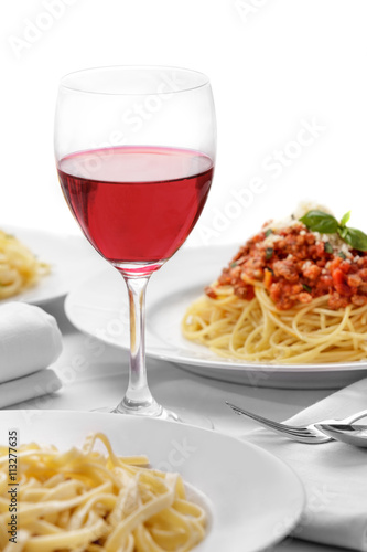 red wine on glass with italian pasta cuisine