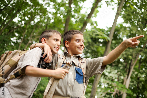 two excited boys on a camping trip in the forest exploring