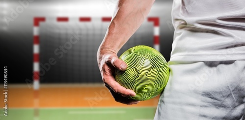 Sportsman holding a ball against digital image of handball goal 