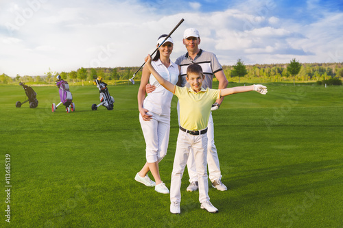 Happy boy golfer plaing golf with parents