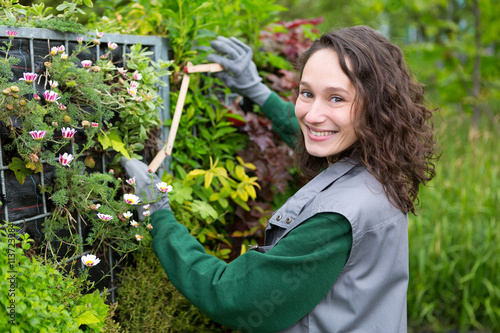 Young attractive landscaper woman working in a public park