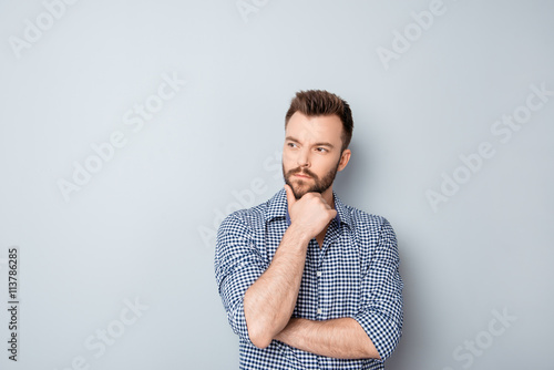 Handsome ponder young businessman isolated on gray background