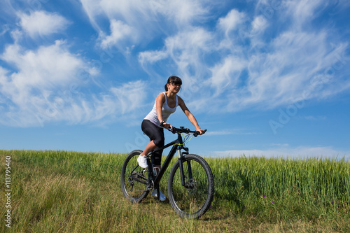 woman going for bike ride on sunny day in countryside