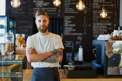 Happy small business owner standing at coffee shop